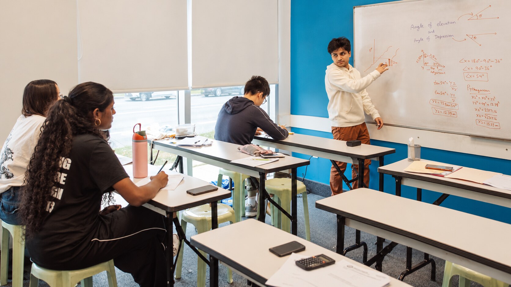 An STS teacher explaining a lesson at the board during class