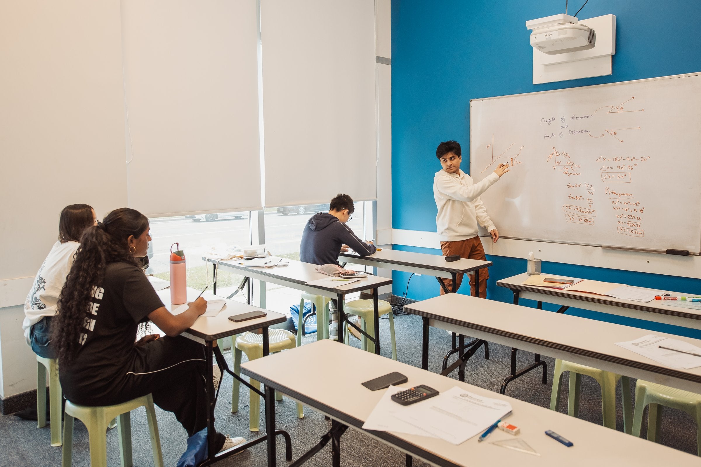 An STS teacher explaining a lesson at the board during class